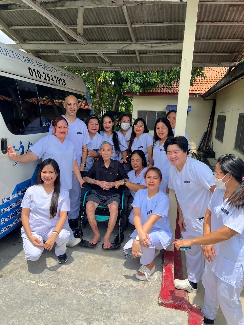 Multicare care team and wheelchair passenger beside our van